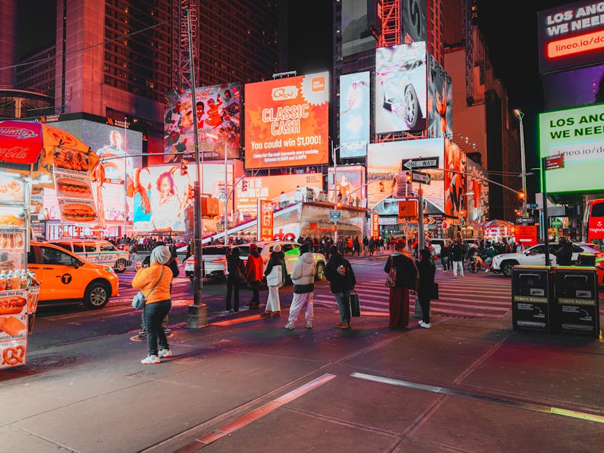 Živahni Times Square noću s jarkim reklamama i raznolikim gomilama