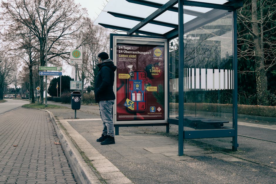 Čovjek na autobusnoj stanici okružen zimskim krajolikom